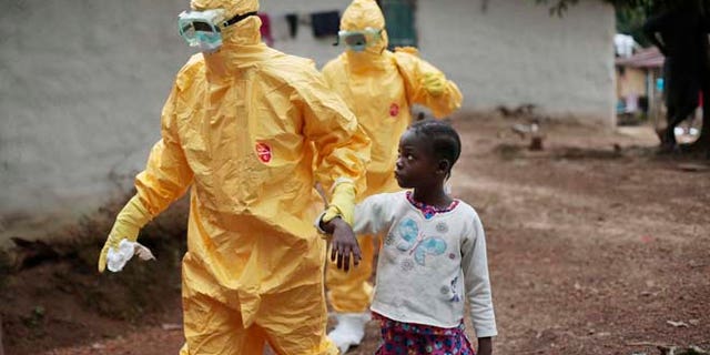 FILE 2014: Nine-year-old Nowa Paye is taken to an ambulance after showing signs of the Ebola virus disease in the village of Freeman Reserve, which is north of Monrovia, Liberia.