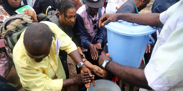 A Congolese health worker instructs residents about washing their hands as a preventive measure against Ebola in Mbandaka, Democratic Republic of Congo