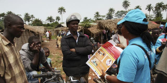 A UNICEF worker speaks with drivers of motorcycle taxis about the symptoms of Ebola virus disease (EVD) and best practices to help prevent its spread, in the city of Voinjama, in Lofa County, Liberia in this April 2014 UNICEF handout photo. (REUTERS/Ahmed Jallanzo/UNICEF)