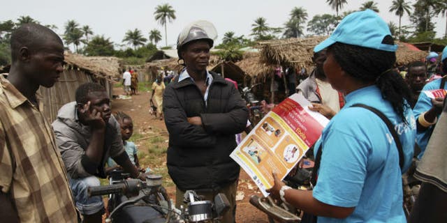 A UNICEF worker speaks with drivers of motorcycle taxis about the symptoms of Ebola virus disease (EVD) and best practices to help prevent its spread, in the city of Voinjama, in Lofa County, Liberia in this April 2014 UNICEF handout photo. (REUTERS/Ahmed Jallanzo/UNICEF)