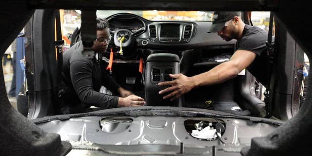 In this March 14, 2014 photo, assembly line workers build a 2015 Chrysler 200 automobile at the Sterling Heights Assembly Plant in Sterling Heights, Mich. Many economists say 2014 will be the year the economic recovery from the Great Recession finally achieves the robust growth that’s needed to accelerate hiring and reduce still-high unemployment. (AP Photo/Paul Sancya)
