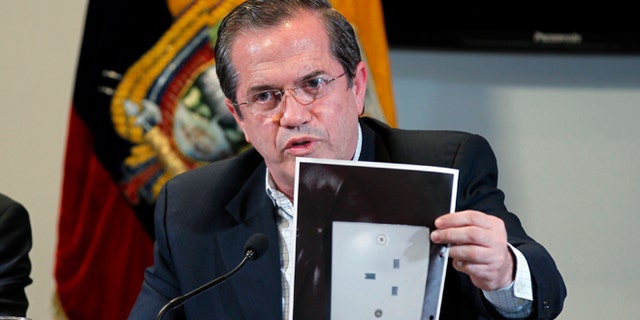 Ecuador's Foreign Minister Ricardo Patino holds up a photograph of what he says is the electric socket at his country's embassy in London where a hidden microphone was found, during a press conference in London in Quito, Ecuador, Wednesday, July 3, 2013. Patino said that two weeks ago a hidden microphone was found where Wikileaks founder and publisher Julian Assange is holed up. "We want to find out with precision what the origin of the apparatus is."  (AP Photo/Dolores Ochoa)