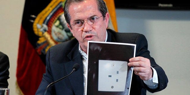 Ecuador's Foreign Minister Ricardo Patino holds up a photograph of what he says is the electric socket at his country's embassy in London where a hidden microphone was found, during a press conference in London in Quito, Ecuador, Wednesday, July 3, 2013. Patino said that two weeks ago a hidden microphone was found where Wikileaks founder and publisher Julian Assange is holed up. "We want to find out with precision what the origin of the apparatus is." (AP Photo/Dolores Ochoa)