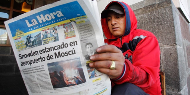 A man reads a newspaper with the headline in Spanish "Snowden stuck at Moscow airport" in Quito, Ecuador, June 26, 2013.