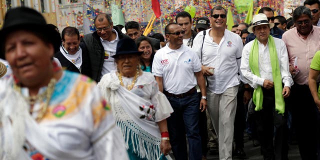 FILE - In this Friday, May 1, 2015, file photo, Ecuador's President Rafael Correa, third from the right, marches in the May Day parade in Quito, Ecuador. Ecuadors leader halted his motorcade when a 16-year-old appeared to make an obscene gesture at him, Correa got out and confronted the teenager. Officials say the boy was detained and later sentenced to 20 hours of community service for making offensive gestures at the president on May 1. (AP Photo/Dolores Ochoa, File)