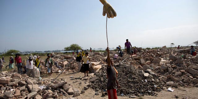 A man looking for recyclable items in a field of post-earthquake debris, in Manta, Ecuador, Wednesday, April 20, 2016.
