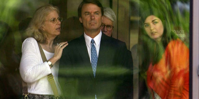 Former presidential candidate John Edwards, center, is seen with his daughter Cate, right, as they peer out of the federal building following a court appearance in Winston-Salem, N.C., Friday, June 3, 2011. (AP)