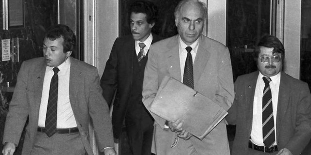 FILE - In this Jan. 22, 1983 file photo, ex-CIA agent Edwin Wilson, center, leaves federal court after a day of jury selection accompanied by U.S. Marshals in Houston.