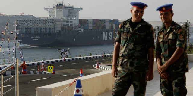 Aug. 6, 2015 - Egyptian army soldiers watch a cargo container ship cross the new section of the Suez Canal after the opening ceremony in Ismailia, Egypt. President Abdel-Fattah el-Sissi, has billed the canal extension as an historic achievement needed to boost the country's ailing economy.