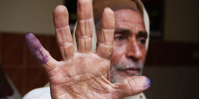 Dec. 14: An Egyptian man shows his inked fingers after casting his vote in Menoufia, Egypt.