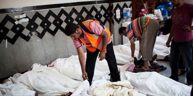 July 27, 2013: An Egyptian doctor identifies the body of a supporter of Egypt's ousted President Mohammed Morsi killed in clashes with security forces at Nasr City, where pro-Morsi protesters have held a weeks-long sit-in, in a field hospital in Cairo, Egypt.