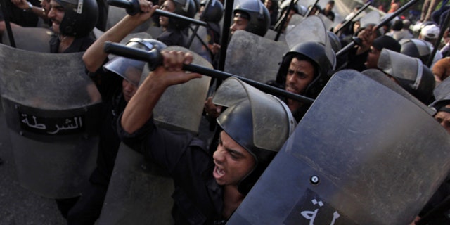 June 11, 2013: Egyptian riot police try to separate Salafis and protesters during clashes in front of the Culture Ministry in Cairo, Egypt.