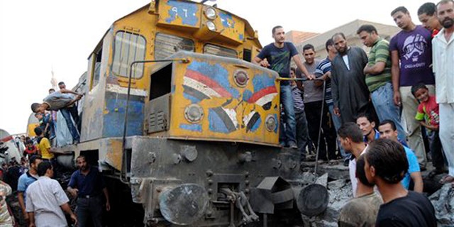 July 17, 2012: Bystanders gather around a derailed train in Badrashin in Giza, Egypt.