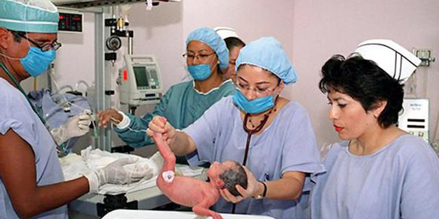 A doctor carries one of the quintuplets, all girls, that a Mexican woman gave birth to in a Cesarean delivery assisted by a 15-doctor team at a Mexico City hospital Tuesday, Aug. 24, 2004. (AP Photo)