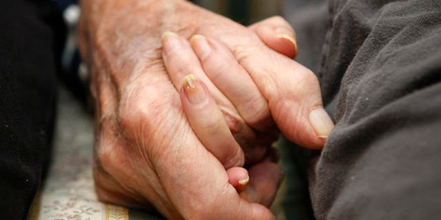 **HOLD FOR RELEASE UNTIL AT 4 P.M. EST MONDAY. MARCH 10, 2008. THIS STORY MAY NOT BE POSTED ONLINE, BROADCAST OR PUBLISHED BEFORE 4 P.M. EST.** Jeannette Zeltzer, 81 and her new boyfriend Max Rakov, 92, hold hands while sitting on a couch at the assisted living facility where they live on Saturday, March 8, 2008 in Newton, Mass.  Zeltzer recently lost her husband and now spends time holding hands with Rakov who also suffers from Alzheimer's.   (AP Photo/Greg M. Cooper)