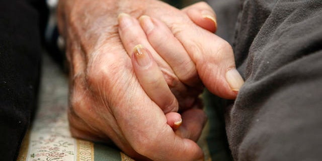 **HOLD FOR RELEASE UNTIL AT 4 P.M. EST MONDAY. MARCH 10, 2008. THIS STORY MAY NOT BE POSTED ONLINE, BROADCAST OR PUBLISHED BEFORE 4 P.M. EST.** Jeannette Zeltzer, 81 and her new boyfriend Max Rakov, 92, hold hands while sitting on a couch at the assisted living facility where they live on Saturday, March 8, 2008 in Newton, Mass. Zeltzer recently lost her husband and now spends time holding hands with Rakov who also suffers from Alzheimer's. (AP Photo/Greg M. Cooper)