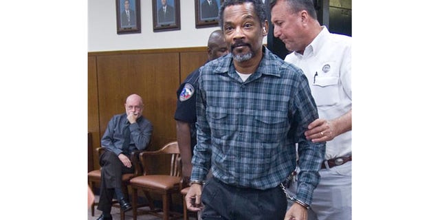 September 13: Defendant Billy Joe Harris enters the Jackson County courtroom in handcuffs and leg shackles in Edna, Texas.