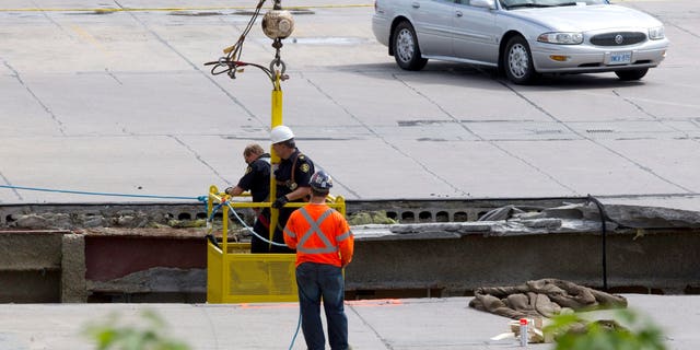 June 25, 2012: OPP officers inspect the damage from the roof as rescue workers continue attempts to secure the building before searching for any survivors at the site of the collapsed roof of the Algo Centre Mall in Elliot Lake, Ontario.
