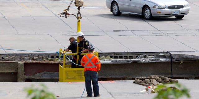 June 25, 2012: OPP officers inspect the damage from the roof as rescue workers continue attempts to secure the building before searching for any survivors at the site of the collapsed roof of the Algo Centre Mall in Elliot Lake, Ontario.