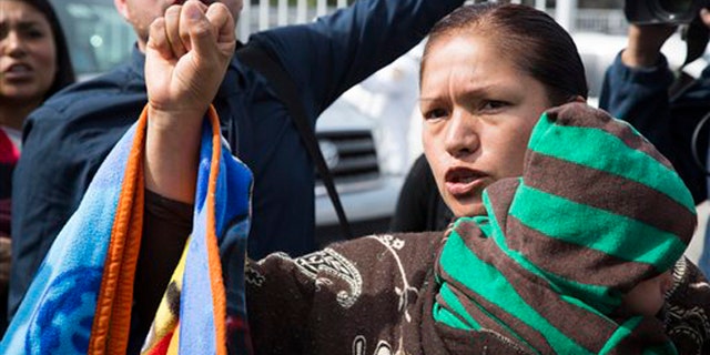 Immigrant rights activist Elvira Arellano waits to enter into the United States where she planned to ask for asylum in Tijuana, Mexico, Tuesday, March 18, 2014. Arellano and another 20 Mexican and Central American migrants crossed into the United States from the border city of Tijuana as part of a protest to demand an overhaul of U.S. immigration laws and an end to deportations. (AP Photo/Alex Cossio)
