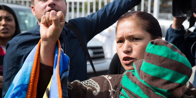 Immigrant rights activist Elvira Arellano waits to enter into the United States where she planned to ask for asylum in Tijuana, Mexico, Tuesday, March 18, 2014. Arellano and another 20 Mexican and Central American migrants crossed into the United States from the border city of Tijuana as part of a protest to demand an overhaul of U.S. immigration laws and an end to deportations. (AP Photo/Alex Cossio)