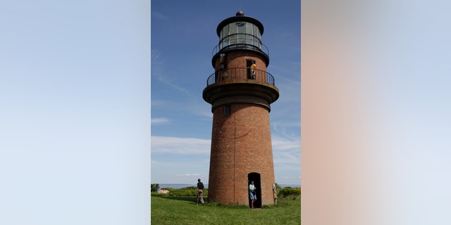 FILE - In this Aug. 27, 2009, file photo, President Barack Obama, left, walks around Gay Head Lighthouse while on vacation on Martha's Vineyard in Aquinnah, Mass. Thie lighthouse is on The National Trust for Historic Preservation 2013 list of 11 Most Endangered Historic Places. The lighthouse was the first lighthouse built on Marthaâs Vineyard in Massachusetts and now is in danger of toppling over the edge of the Gay Head Cliffs. Preservationists say itâs threatened by a century of erosion at the oceanfront site and the impacts of climate change. (AP Photo/Alex Brandon, File)