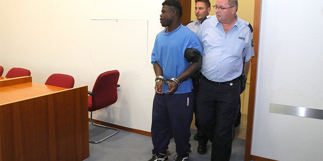 Eric X. walking in the courtroom in Bonn.