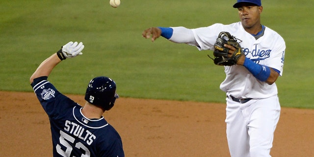 LOS ANGELES, CA - AUGUST 20: Erisbel Arruebarrena #11 of the Los Angeles Dodgers makes a throw to complete a double play in front of Eric Stults #53 of the San Diego Padres during the second inning at Dodger Stadium on August 20, 2014 in Los Angeles, California. (Photo by Harry How/Getty Images)