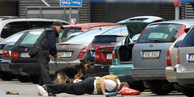 August 11:Estonian police officers check the area for explosives near the Defense Ministry building in Tallinn, Estonia. A gunman opened fire inside the building as he tried to take hostages but he apparently was shot and killed by police. The attacker entered the ministry at midday, threw a smoke bomb, fired shots and tried to kidnap two employees.