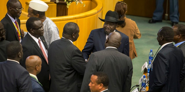 Aug. 17, 2015: South Sudan's rebel leader Riek Machar, center-left with back to camera, shakes hands with South Sudan's President Salva Kiir, center-right wearing a black hat, after lengthy peace negotiations in Addis Ababa, Ethiopia. Kiir refused to sign a peace agreement Monday with rebel forces, saying he needs 15 days before he will sign, although Machar had signed the accord before Kiir refused. (AP Photo/Mulugeta Ayene)