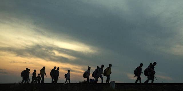 FILE - This is a Thursday Sept. 3, 2015 file photo of a group of refugees as they walk along the railway tracks near the town of Roszke, Hungary, after crossing the border from Serbia. Among the tens of thousands fleeing war and despair in the Middle East, one group feels a special relief in reaching Europe: those who have escaped areas ruled by Islamic State extremists and the harsh scrutiny of their religious police. (AP Photo/Santi Palacios, File)