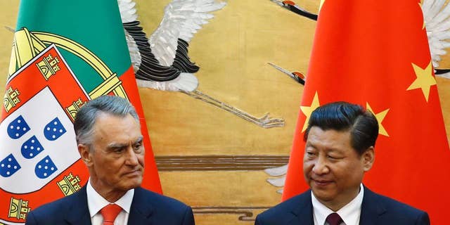 FILE - In this May 15, 2014, file photo, Portugal's President Anibal Cavaco Silva, left, and China's President Xi Jinping attend a signing ceremony at the Great Hall of the People in Beijing. When two Chinese companies appeared among the bidders to buy a troubled Portuguese bank this year, its staff took heart. They believed the potential buyers would do what Chinese investors are increasingly doing in Europe: save badly needed jobs and invest in expanding the business. (Kim Kyung-hoon/Pool Photo via AP)