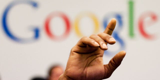 FILE - In this Oct. 17, 2012, file photo, a man raises his hand during at Google offices in New York. People should have some say over the results that pop up when they conduct a search of their own name online, Europe's highest court said Tuesday, May 13, 2014. (AP Photo/Mark Lennihan, File)