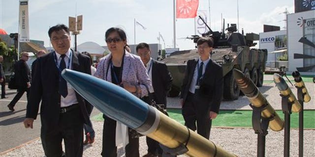 Visitors walk past 76/62mm ammunition manufactured by Italian company Oto Melara, Italy, presented at the Eurosatory show.