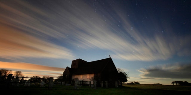 In this two-minute exposure, the rising moon illuminates clouds sweeping across the evening sky over St. Martin's In The Field, an Episcopal summer chapel in Biddeford Pool, Maine. With the winter solstice, Maine now receives only about nine hours of daylight.