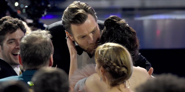 Ewan McGregor, left, kisses Mary Elizabeth Winstead before accepting the award for best actor in a movie made for TV or limited series for "Fargo" at the 23rd annual Critics' Choice Awards at the Barker Hangar on Thursday, Jan. 11, 2018, in Santa Monica, Calif.