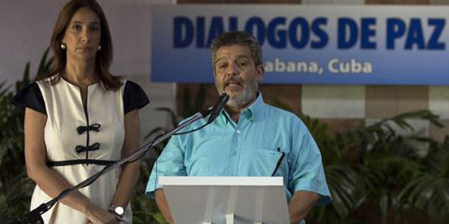 Accompanied by Marcela Duran, left, the Colombian government delegation's head of press, Marco Leon Calarca, member of the Revolutionary Armed Forces of Colombia, or FARC, speaks during the announcement of a deal on bilateral cease-fire that would be the last major step toward ending one of the world’s longest wars, in Havana, Cuba, Wednesday, June 22, 2016. (Cubadebate via AP)