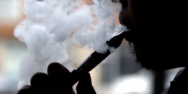 Daryl Cura demonstrates an e-cigarette at Vape store in Chicago, Wednesday, April 23, 2014. The federal government wants to ban sales of electronic cigarettes to minors and require approval for new products and health warning labels under regulations being proposed by the Food and Drug Administration. (AP Photo/Nam Y. Huh)