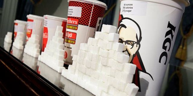 FILE - This May 31, 2012 file photo shows a display of various size soft drink cups next to stacks of sugar cubes at a news conference at New York's City Hall. Its one of our most personal daily decisions: what to eat or drink. Maybe inhale. Does banning trans fat from our food mean the government is getting serious about cracking down on all sorts of other unhealthy stuff: Soda? Salt? Cigarettes? Alcohol? Probably not. In fact, in some states, theyre easing the way for marijuana. (AP Photo/Richard Drew, File)