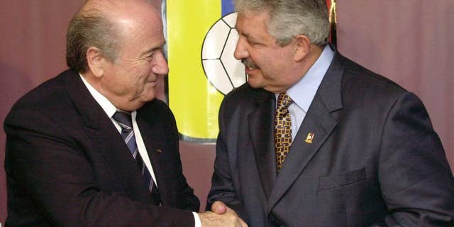 FILE - In this Nov. 8, 2004 file photo Sepp Blatter, President of the FIFA, left, shakes hands with the President of the Venezuelan Soccer Federation, Rafael Esquivel, in Caracas, Venezuela. A senior South American soccer official has been denied bail on health grounds in Switzerland as he fights extradition to the United Sates after being indicted in the FIFA bribery case. CONMEBOL vice president Rafael Esquivel of Venezuela, one of seven soccer officials arrested in Zurich in May, is currently in hospital in Switzerland, the Federal Office of Justice told The Associated Press on Monday, Oct. 5, 2015. (AP Photo/Leslie Mazoch, File)