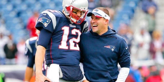 Oct 26, 2014; Foxborough, MA, USA; New England Patriots quarterback Tom Brady has a laugh with offensive coordinator Josh McDaniels before the game between the New England Patriots and the Chicago Bears at Gillette Stadium. Mandatory Credit: Winslow Townson-USA TODAY Sports