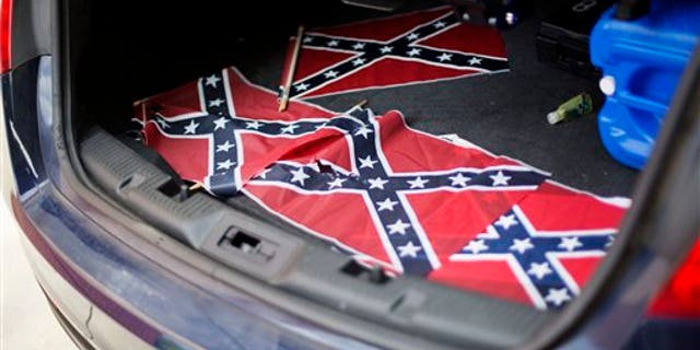 Confederate flags sit in the back of a police car outside Ebenezer Baptist Church Thursday, July 30, 2015, in Atlanta. U.S. authorities are investigating after several Confederate battle flags were discovered near the church and a civil rights center named after Martin Luther King, an iconic leader in the African-American Civil Rights Movement, Thursday morning. (AP Photo/David Goldman)