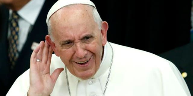 Pope Francis reacts as he listens children's singing while arrives to visit a classroom in Our Lady Queen of Angels School in the East Harlem, neighborhood of New York, Friday, Sept. 21, 2015. (Kena Betancur/Pool Photo via AP)