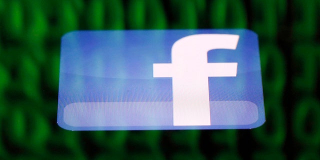 A Facebook logo on an Ipad is reflected among source code on the LCD screen of a computer, in this photo illustration taken in Sarajevo June 18, 2014. Ireland's High Court on Wednesday asked the European Court of Justice (ECJ) to review a European Union-U.S. data protection agreement in light of allegations that Facebook shared data from EU users with the U.S. National Security Agency. REUTERS/Dado Ruvic (BOSNIA AND HERZEGOVINA - Tags: CRIME LAW BUSINESS POLITICS) - RTR3UH34