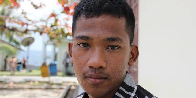 In this Thursday, Sept. 10, 2015 photo, a Burmese fisherman who goes by the name of "Bing" hangs out at the port in Ambon, Maluku province, Indonesia. Like more than 2,000 other fishermen rescued following reporting by The Associated Press and a subsequent Indonesian investigation, Bing, 18, was forced to work on a fishing boat with no way to return to his homeland. Unlike the others, he still can’t go back. (AP Photo/Robin McDowell)