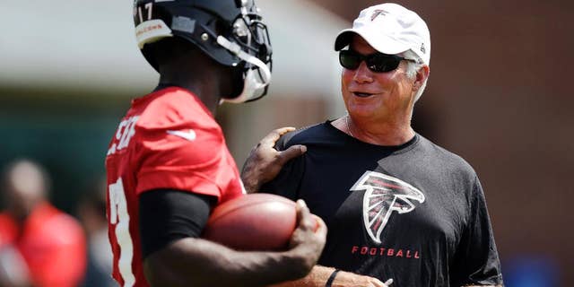 FILE - In this June 17, 2014, file photo, Atlanta Falcons head coach Mike Smith, right, talks with Devin Hester during NFL football minicamp in Flowery Branch, Ga. (AP Photo/David Goldman, File)