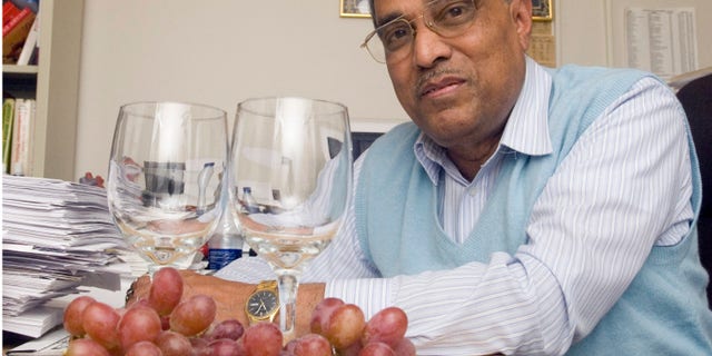 This 2006 photo shows Dipak Das with grapes and wine glasses at his office at the UConn Health Center in Farmington, Conn.