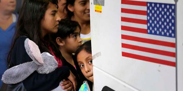 In this Tuesday, July 7, 2015, photo immigrants from El Salvador and Guatemala who entered the country illegally board a bus after they were released from a family detention center in San Antonio. Women and children are being released from immigrant detention centers faster on bond, with many mothers assigned ankle-monitoring bracelets in lieu of paying. (AP Photo/Eric Gay)