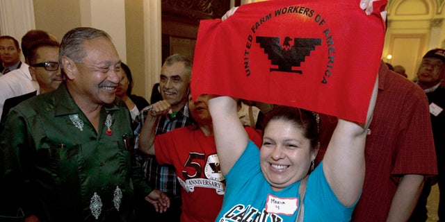 Maria Ceja and other farm workers celebrate outside the Assembly Chambers in Sacramento, Calif. Calif.