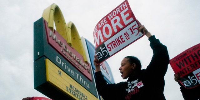Fast-food worker Michelle Osborn, 23, of Flint shouts out chants as she and a few dozen others strike outside of McDonald's on Wednesday, July 31, 2013 in Flint.  Some fast food restaurant workers have walked off the job in the Detroit area as part of an effort to push for higher wages. Organizers say they began the walkout at restaurants in Lincoln Park and Southfield on Tuesday night. Workers in Flint hit the street Wednesday outside a McDonald's, saying they want wages "super-sized." Workers want $15 and hour, better working conditions and the right to unionize. The restaurant industry says higher wages would hurt job creation. The actions follow strikes this week in other parts of the country. (AP Photo/The Flint Journal, Jake May) LOCAL TV OUT; LOCAL INTERNET OUT